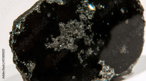 Volcanic obsidian texture with magnetite inclusions. Glassy black surface for geological illustrations