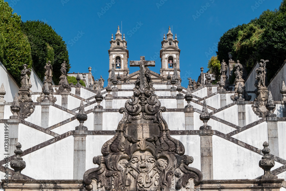 Fototapeta premium Arquitetura religiosa portuguesa com detalhes da escadaria branca e parte da fonte de granito no santuário do Bom Jesus do Monte em Braga, património mundial da UNESCO