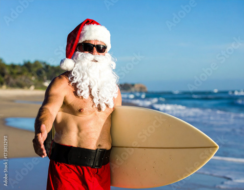 Père Noël sur une plage, face aux vagues, planche de surf à la main