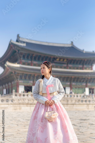 A woman in a traditional Korean hanbok stands gracefully at Gyeongbokgung Palace in Seoul, South Korea, blending history and culture in a timeless scene.”