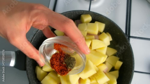 Chef woman hands cooking seasoning potatoes with spices in frying pan on kitchen. Culinary techniques, homemade preparing healthy meal cook meat vegetable food, organic cuisine from fresh ingredients.