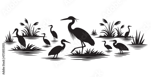 Elegant silhouettes of herons wading through a peaceful wetland marsh at dawn.