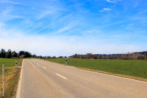 Road near Böbing in the district of Weilheim-Schongau in Bavaria on a sunny spring day with a blue sky