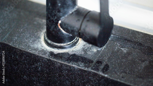 White scale from hard water on black bathroom faucets, industry