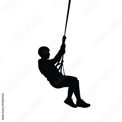 Silhouette of person zip lining with a rope and harness