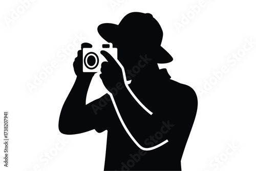 Silhouette of a person wearing a hat taking a picture with a camera