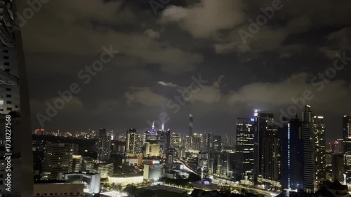 Kuala Lumpur skyline at night featuring illuminated skyscrapers, the iconic Merdeka 118 tower, and vibrant city lights under cloudy skies