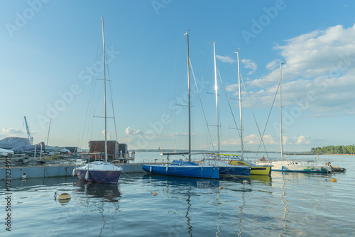 Tableau sur toile Sailboats docked at quiet marina under clear blue sky