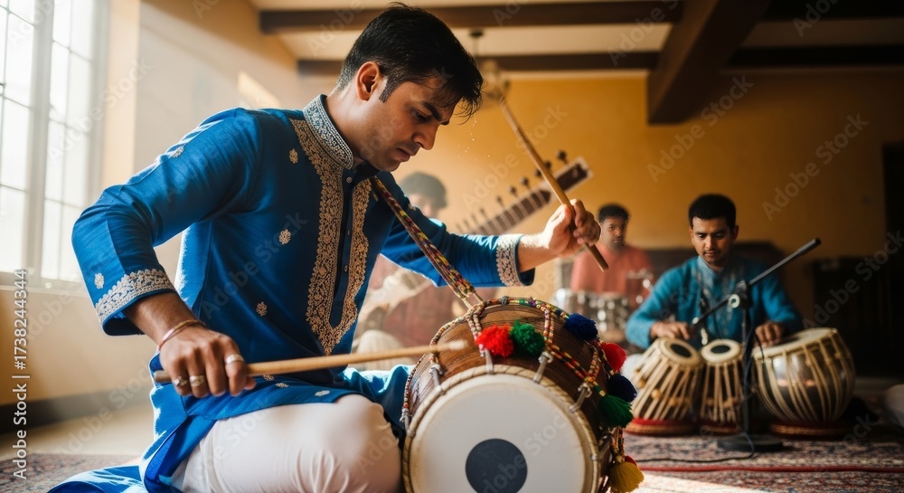 Fototapeta premium Indian traditional drum player rehearses indoors with fellow musicians during a cultural music session