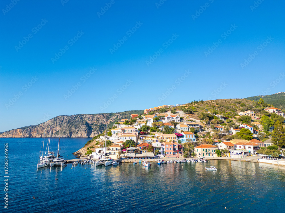 Naklejka premium Assos greek Village. Wide View of Colorful Houses, Yachts in the Harbor, and Cliffs on the Kefalonia Coast