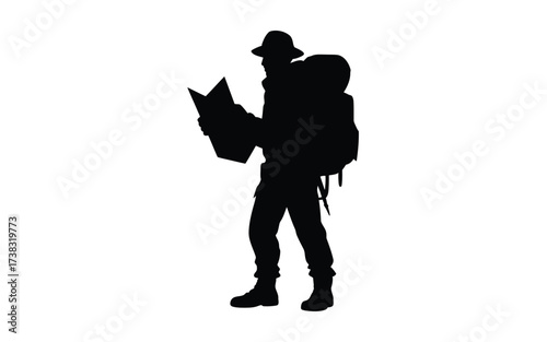 Silhouette of a hiker with a backpack studying a map in the wilderness
