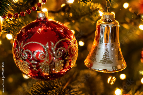Vintage Christmas tree background with red ball, golden bell and festive lights, selective focus