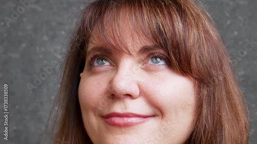 Beautiful woman 40-50 years old smiling and looking around close-up gray eyes showing different joyful emotions
