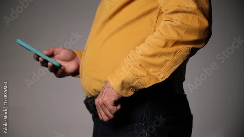 Middle-Aged Man Standing and Using a Smartphone