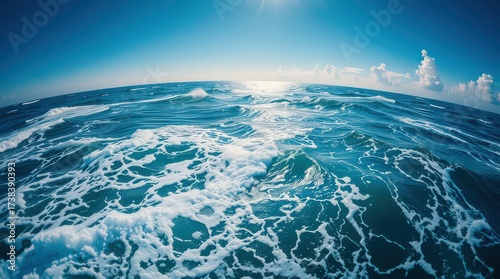 Fototapeta Naklejka Na Ścianę i Meble -  A captivating view of the ocean under a clear blue sky with sunlight