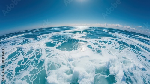 Fototapeta Naklejka Na Ścianę i Meble -  A breathtaking view of the ocean with foamy waves under a clear blue sky