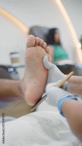 Professional manicurist giving pedicure at beauty spa