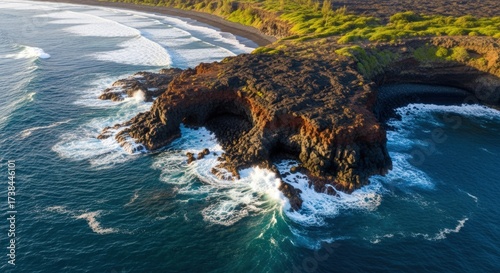 Aerial view of a rugged coastline with black lava rocks meeting the turquoise ocean in maui, hawaii, showcasing the raw beauty and volcanic origins of the island