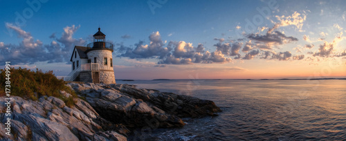 Historic Coastal Lighthouse on Rocky Shore at Golden Hour
