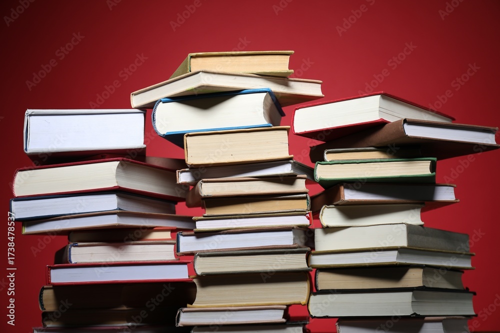 Fototapeta premium Many different books against red background, closeup