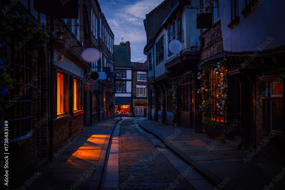 Fototapeta premium York city's historic alley at sunrise, featuring well-preserved landmark architecture and medieval timber-framed buildings, a popular tourist attraction and shopping area in Yorkshire, England.