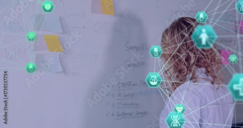Teenage presenter writing bullet points on board as green hexagon network growing for education