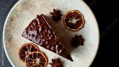 A slice of sweet layered cake covered in chocolate with nuts and caramel. A slice of chocolate cake