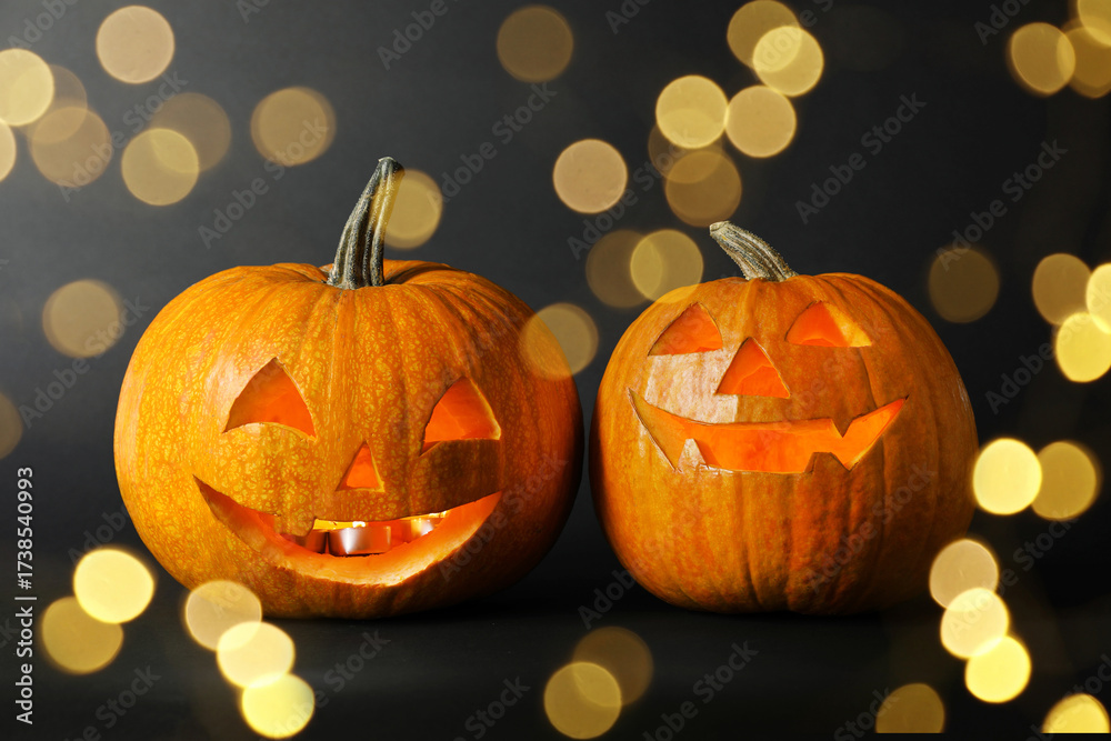 Fototapeta premium Halloween jack-o-lanterns. Pumpkins with carved creepy faces, bokeh effect