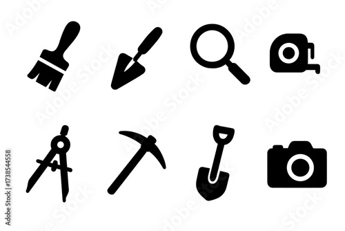 Archaeological Tools Icons. Solid, filled icon set of archaeological tools: brush, trowel, magnifying glass, measuring tape, compass, pickaxe, shovel, camera.