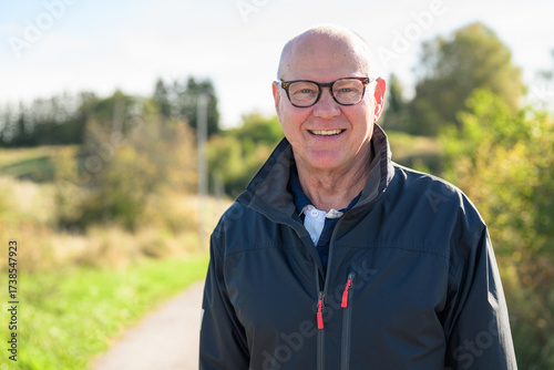 Portrait of a smiling Nordic senior man in sportswear standing outdoors