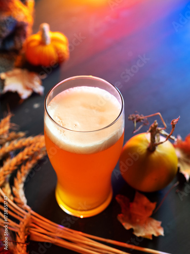 Pumpkin beer glass on a table with wheat ears