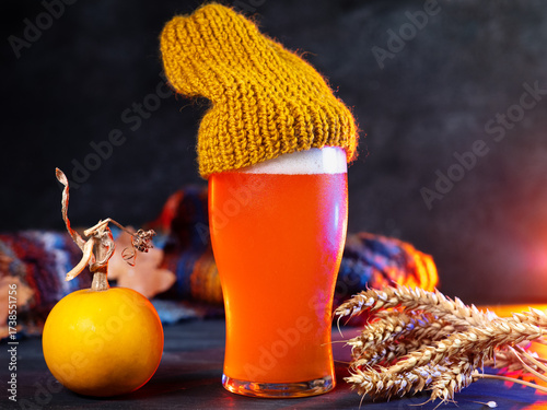Craft pumpkin beer glass on the table. Autumn decor. Seasonal festival beer.