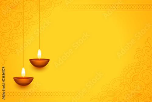 Two illuminated diyas hanging against a vibrant yellow background with decorative borders