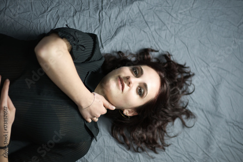 brunette model poses sensually in a photo studio for a fashion magazine