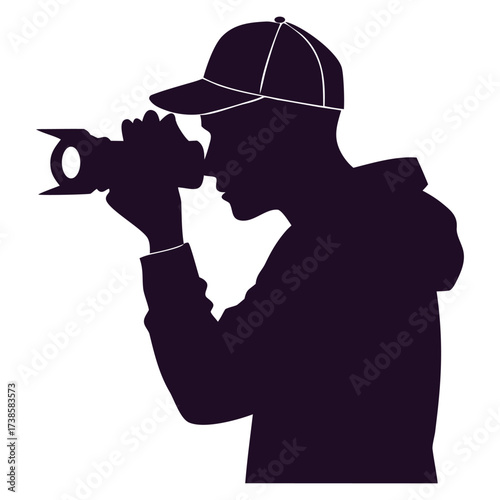 Silhouette of a person wearing a hat holding and operating a video camera