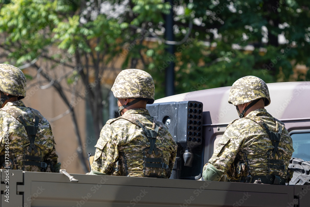 Fototapeta premium Three soldiers in military truck at sunny summer day