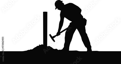 Silhouette of construction worker using pickaxe tool to dig or break ground at work site, showing manual labor, effort, and building industry activity