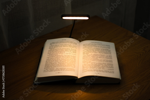 A convenient clip-on reading lamp with color options, placed over a book on the table for reading