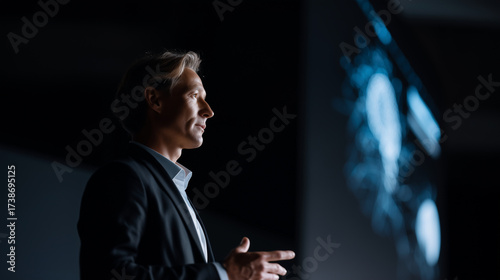 Professional speaker at artificial intelligence forum, futuristic graphics on screen, AI technology presentation AI forum, professional speaker, technology event, innovation stage,