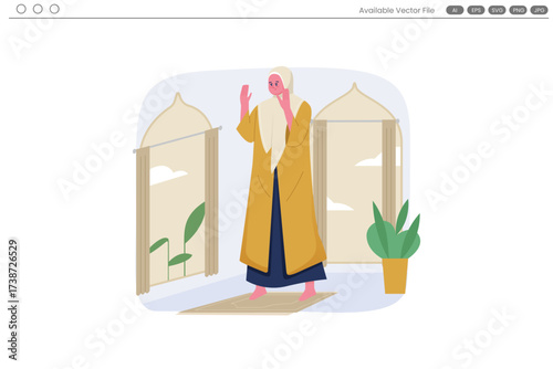 A woman in hijab prays on a mat in front of windows