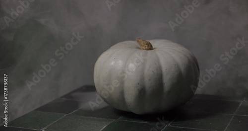 Halloween theme. Light green pumpkin with mystic smoke and orange light in background