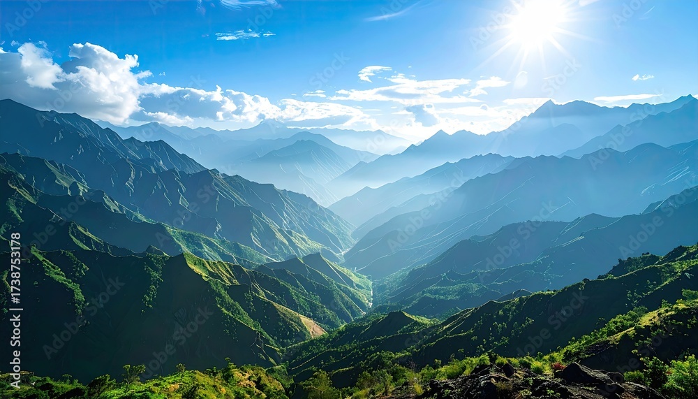 Fototapeta premium Lush Green Mountain Range Under Bright Sunlight and Clear Blue Sky Scenery with Distant Peaks and Mist in Daytime Scenic Landscape