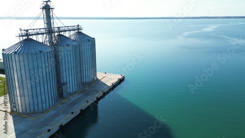 Stunning Aerial Drone View of Modern Grain Silos at a Commercial Seaport on a Sunny Day