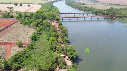 Drone view of Rio Pardo river with bridge and preserved native vegetation in Barretos and Guaíra, São Paulo, Brazil