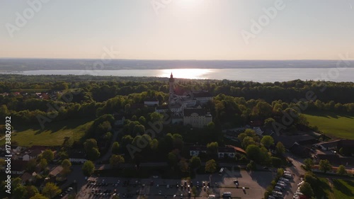 Luftaufnahme Kloster Andechs bei Muuenchen, Bayern. Drohnenvideo Wallfahrtskirche auf dem Heiligen Berg am Ammersee mit Landschaft, See und Sonnenuntergang. Burg Andechs. Braustuberl des Klosters. 