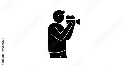 Silhouette of a person holding a vintage video camera, filming something in the distance.