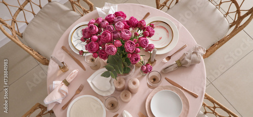 Beautiful table setting with pink roses and candles for wedding celebration in room, top view