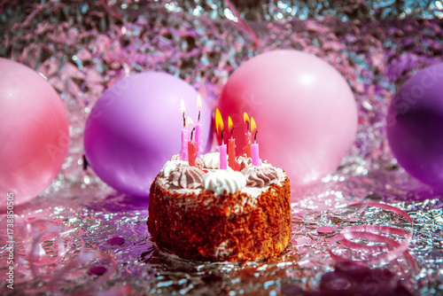 Happy birthday cake with burning candles with pink and purple air balloons  on silver background 