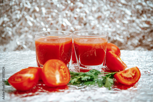 Red Tomato  juice with green parsley on the glittering background
