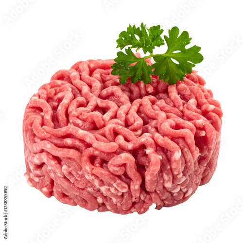 Raw ground meat is presented in a circular shape, viewed in a  setting against a solid black background, showing textured details and a sprig of fresh green parsley, providing contrast.